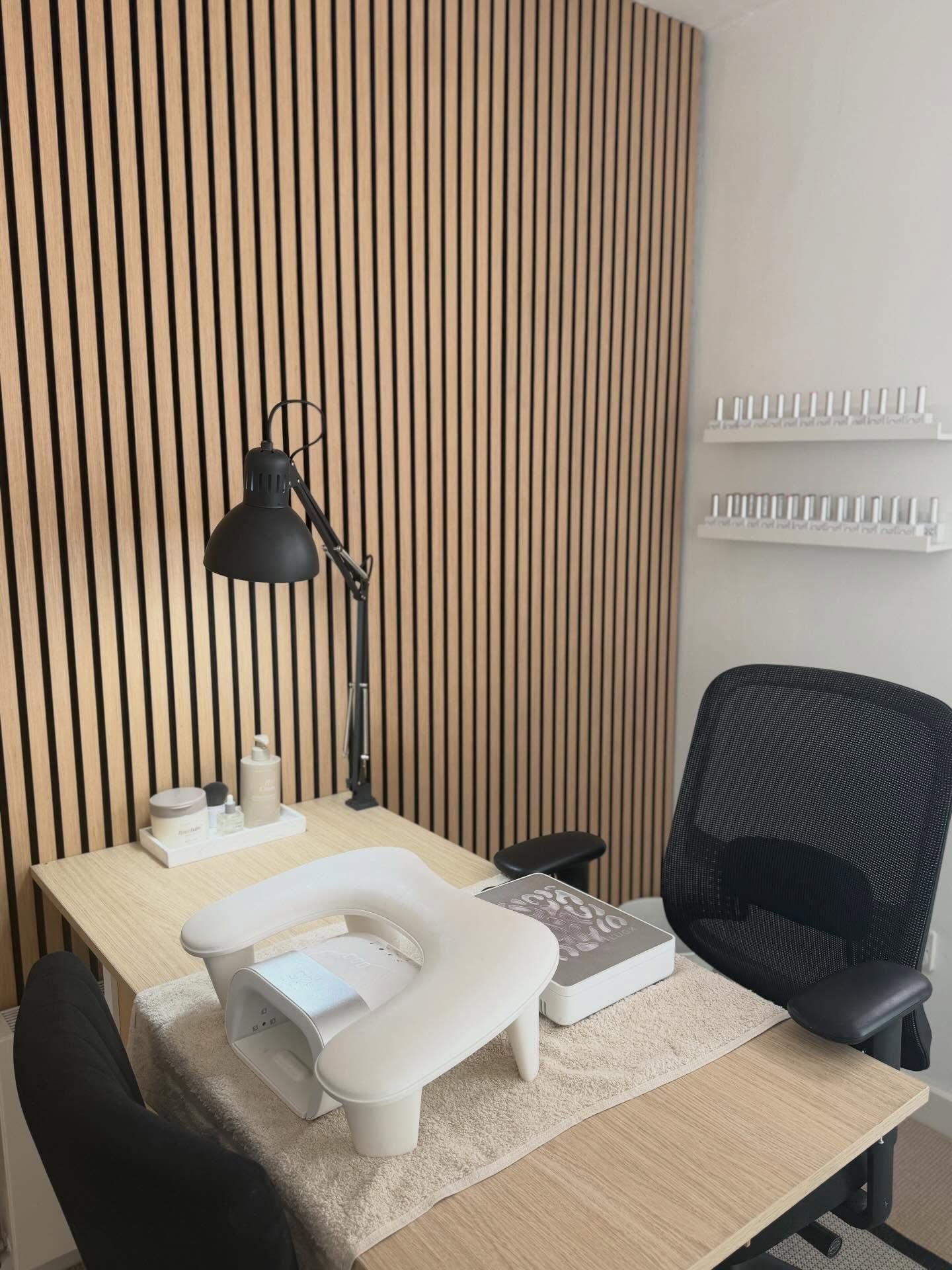 The Kings Hill Manicures home studio: pale wood slatted wall, white desk and nail lamp